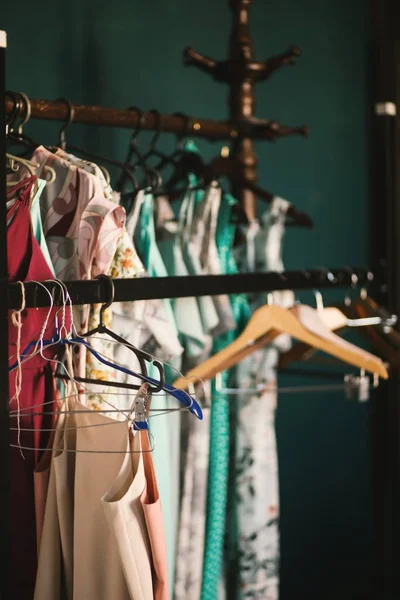 Tiro selectivo vertical de perchas de ropa marrón colgadas en un estante con ropa — Foto de Stock