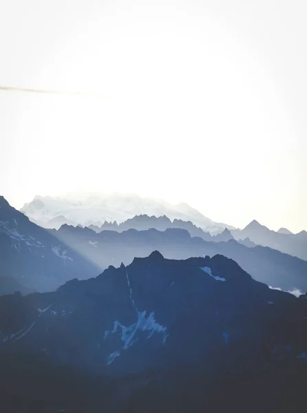 Tiro vertical de montañas bajo un cielo brillante — Foto de Stock