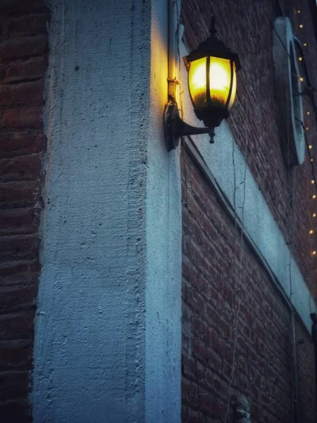 Vertikal bild av en gatlykta knuten till en byggnad vid midnatt — Stockfoto