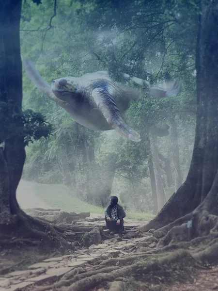 Tiro vertical de un macho sentado entre árboles con una criatura mágica nadando detrás — Foto de Stock
