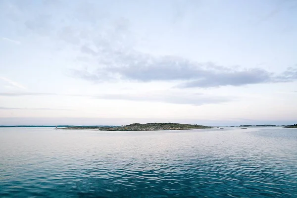 Hermosa toma de un mar con una montaña en el fondo bajo un hermoso cielo —  Fotos de Stock