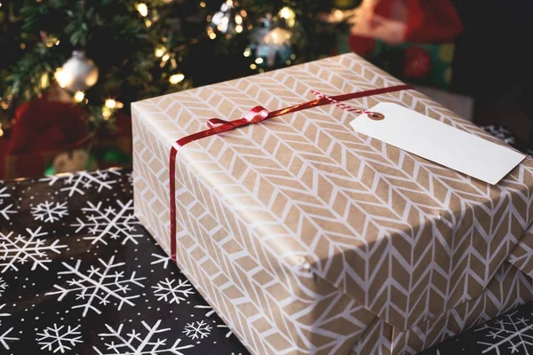 Foto de close-up seletiva de uma caixa de presente decorada de Natal com uma etiqueta em branco como espaço para o seu texto — Fotografia de Stock