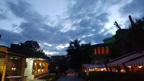 Camino en medio de cafés con edificios en la distancia bajo un cielo nublado en Armenia — Foto de Stock