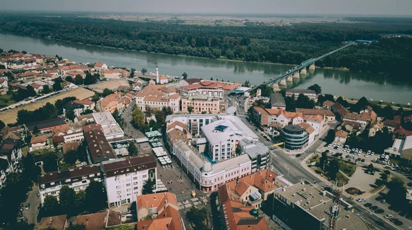 Foto aérea de edificios de la ciudad con un puente sobre el río cerca de árboles y plantas —  Fotos de Stock