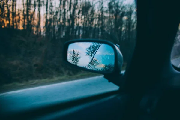 Beautiful shot of trees and the blue sky reflected on a cars side mirror — Stock Photo, Image