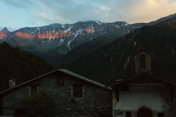 Vecchia chiesa circondata da montagne e alberi — Foto Stock