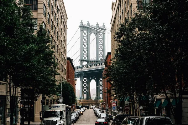 Bred bild av bilar parkerade på Dumbo Street med byggnader nära Brooklyn Bridge i New York — Stockfoto