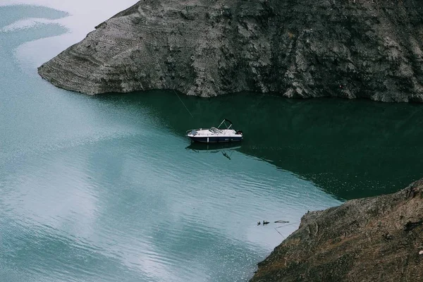 Широкий снимок моторной лодки на водной поверхности посреди гор — стоковое фото