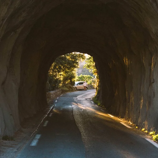 Schöne Aufnahme eines Tunnels mit einem Mann, der in der Nähe eines Autos in der Ferne steht — Stockfoto