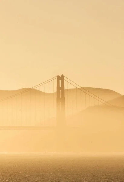 Tiro Vertical Uma Ponte Portão Dourado Nevoeiro Com Céu Laranja — Fotografia de Stock