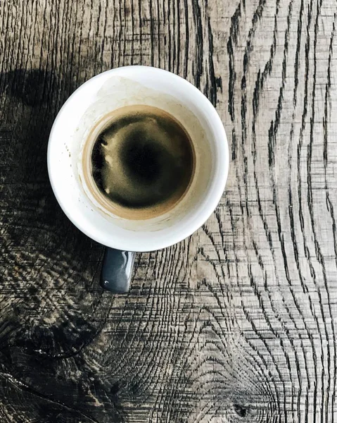 Overhead shot of a cup of coffee on a wooden surface — Stock Photo, Image