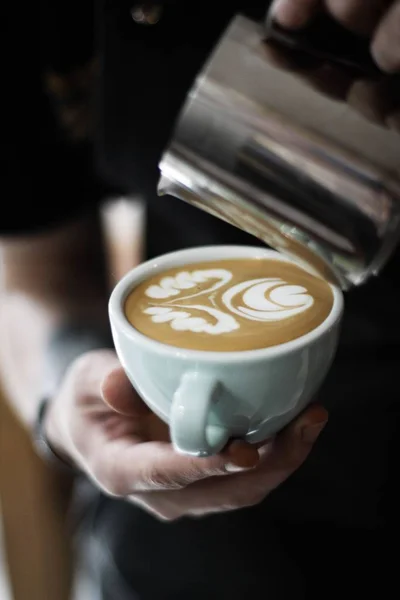 Verticale selectieve close-up shot van een persoon Holding witte keramische Cup met koffie met latte kunst — Stockfoto