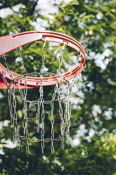 Verticaal close shot van een basketbalring met een wazige achtergrond — Stockfoto