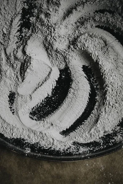 Closeup shot white flour on a black metal cooking tray — Stock Photo, Image