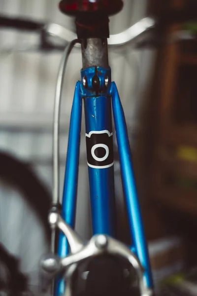Primer plano vertical de una bicicleta azul con un fondo borroso Imagen De Stock