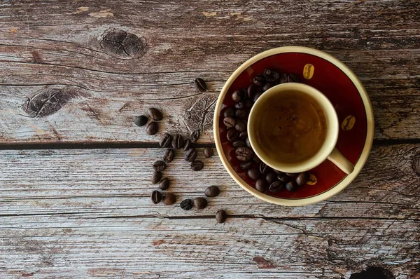 나무 표면에 커피 콩 근처 커피 컵의 오버 헤드 샷 — 스톡 사진