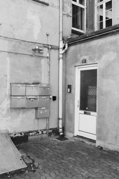 Tiro vertical de uma entrada para um prédio de apartamentos em preto e branco — Fotografia de Stock