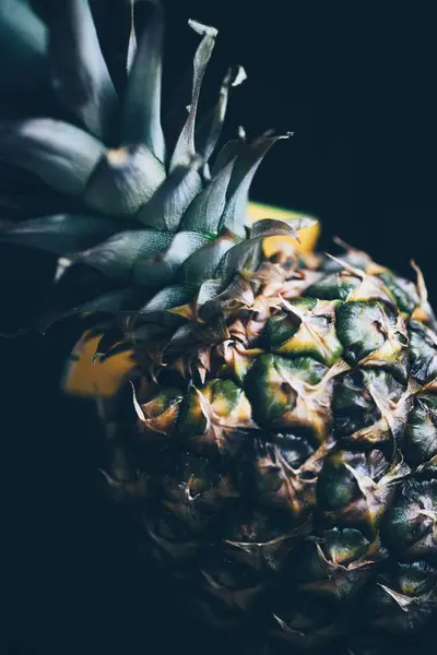 Gros plan vertical d'un ananas au fond sombre et flou — Photo