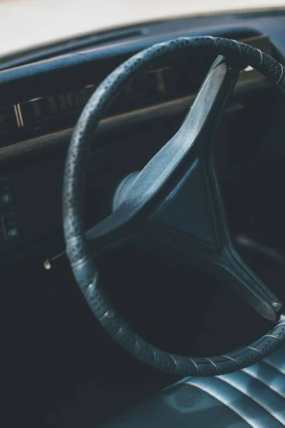 Vertical interior shot of an old car steering wheel with a blurred background — Stock Photo, Image