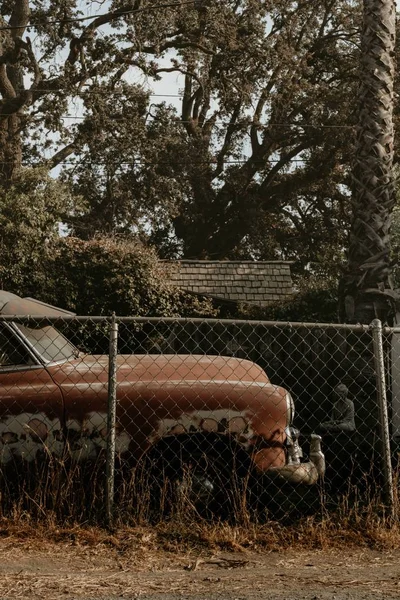 시골에 철조망 옆에 버려진 낡고 녹슨 차 — 스톡 사진