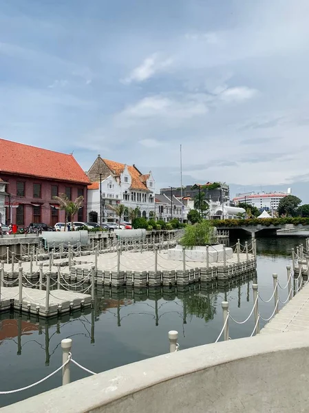 Vertikala skott av hus och bilar nära en brygga på kroppen av vatten under en klar himmel — Stockfoto