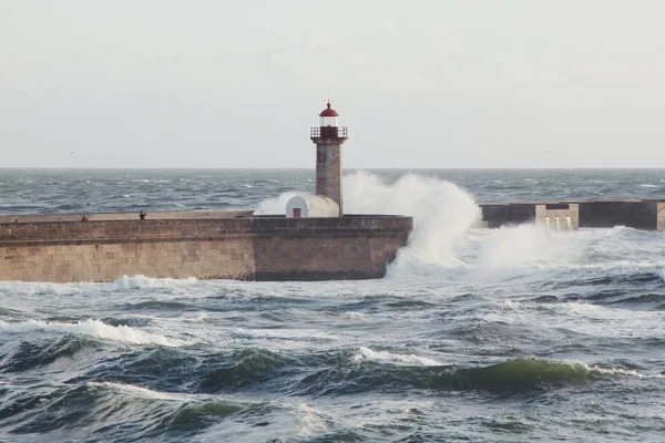 Güçlü Dalgalar Ile Deniz Kıyısında Uzun Bir Deniz Feneri Kule — Stok fotoğraf