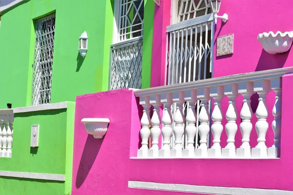 Belo tiro de verde e rosa casas coloridas perto uns dos outros durante o dia — Fotografia de Stock