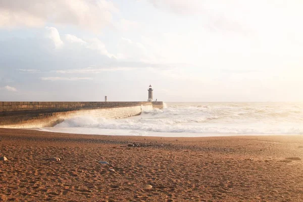 Bellissimo scatto di un alto faro faro torre faro sulla riva del mare con forti onde — Foto Stock