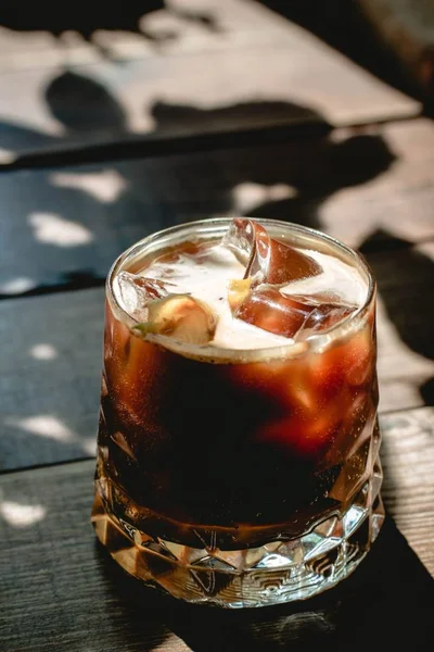 Vertikale selektive Nahaufnahme eines eisalkoholischen Getränks in einem Trinkglas — Stockfoto