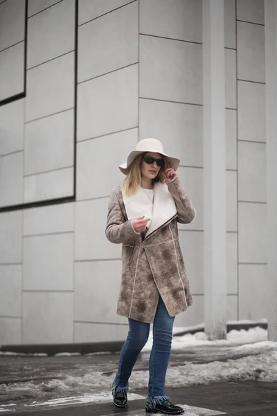 따뜻 한 가죽 외투를 입고 선글라스를 쓰고 모자를 쓴 매력적 인 금발의 여성의 수직 사진 — 스톡 사진