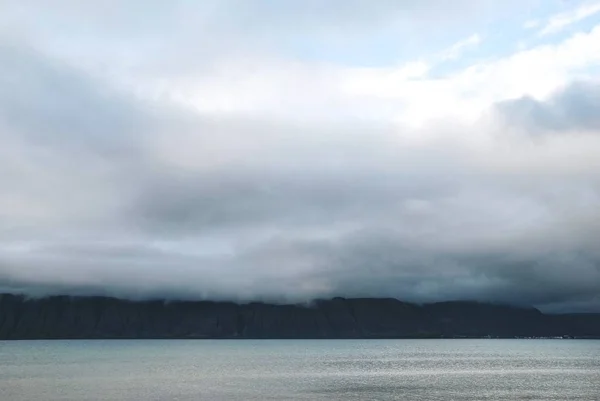 崖や丘のある霧に覆われた海の美しいショットと空の素晴らしい雲 — ストック写真
