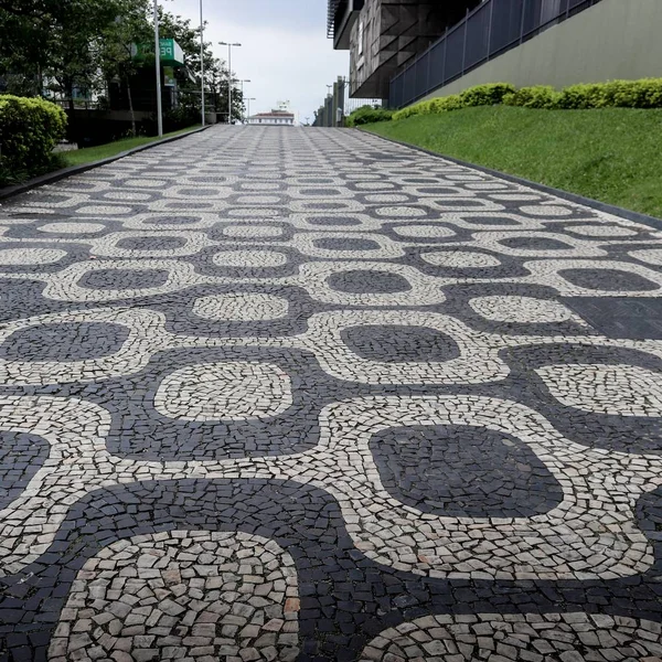 Beautiful shot of mosaic cobbled paving pathway in the middle of buildings near trees in Rio — Stock Photo, Image