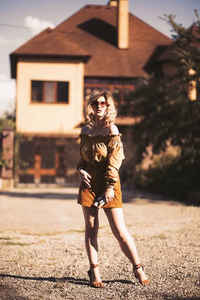 Filme de foco seletivo de um modelo feminino atraente posando perto de uma casa no campo — Fotografia de Stock