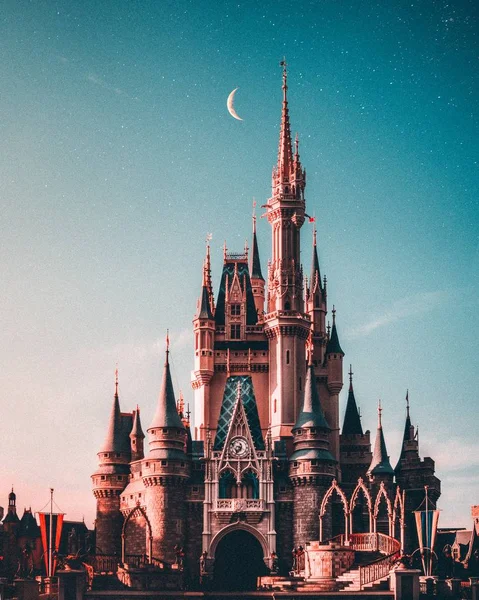 El Castillo de Cenicienta en el parque temático Disney World bajo un cielo nocturno estrellado con media luna — Foto de Stock