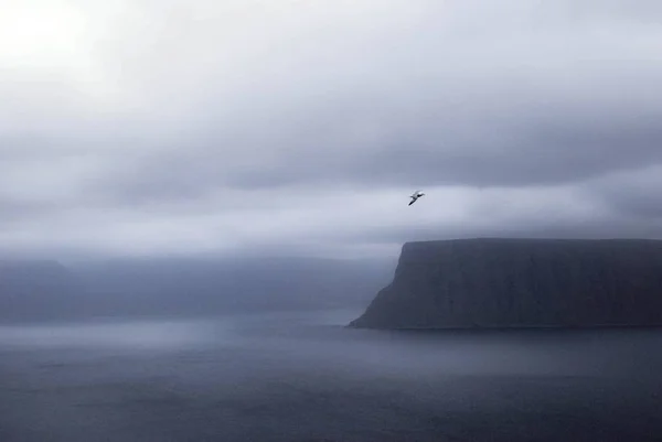 Schöne Aufnahme des nebligen Meeres mit Klippen und Hügeln an der Seite und erstaunlichen Wolken am Himmel — Stockfoto