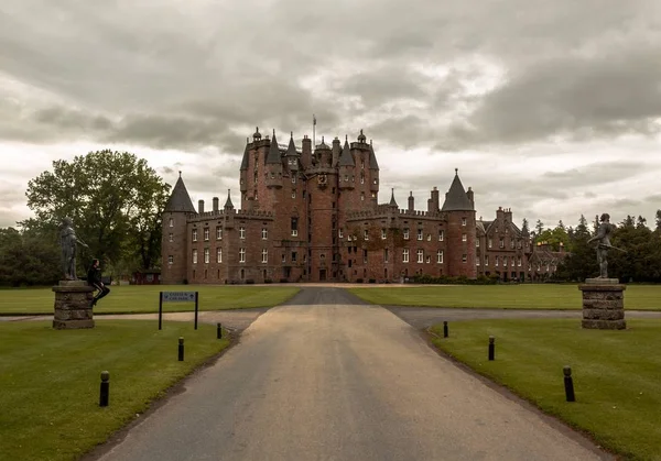 Wide shot of statues at the entrance pathway of the Glamis Castle in Scotland under a cloudy sky — ストック写真