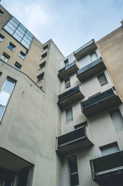 Вертикальний низько під кутом знімок коричневої абстрактної архітектурної будівлі з балконами і вікнами — стокове фото