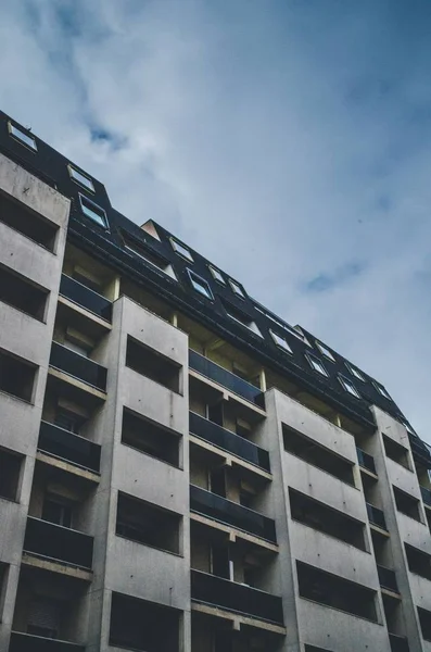 Tiro vertical de ângulo baixo de um edifício azul e branco sob um céu nublado — Fotografia de Stock