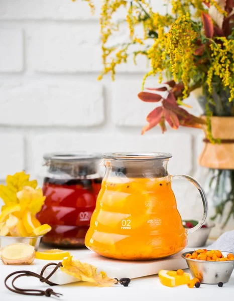 Vertical selective closeup shot of glass pitchers with red tea and cape gooseberry tea — Stock Photo, Image