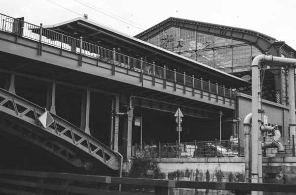Grayscale záběr architektonické budovy v blízkosti mostu nad silnicí — Stock fotografie