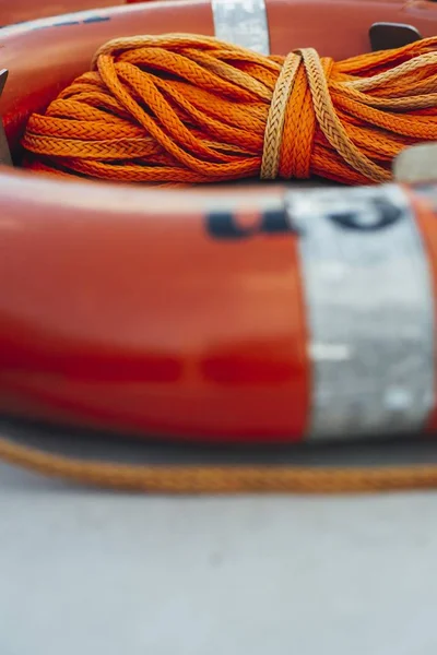 Tiro vertical de uma bóia de anel borrada com uma corda laranja no meio — Fotografia de Stock