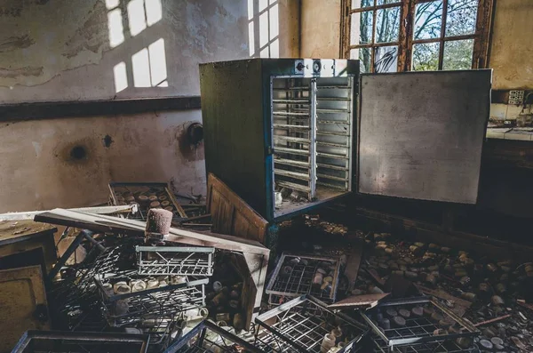 Куча ржавого металла и открытый выветриваемый холодильник в заброшенном здании — стоковое фото