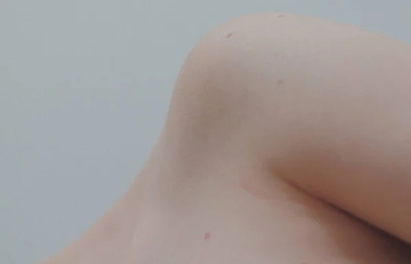 Крупный план обнаженного мягкого плеча женщины на белом фоне — стоковое фото