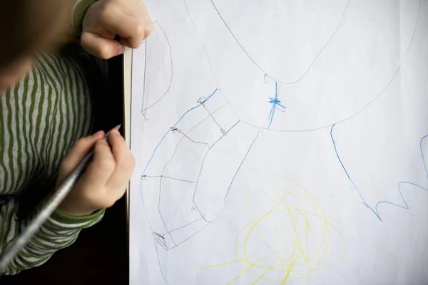 Over headshot of a kid drawing on the paper — Stock Photo, Image