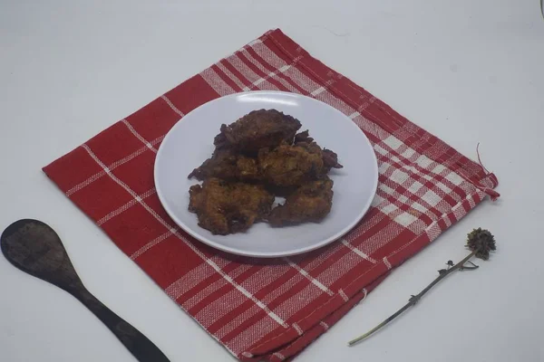 Gros plan d'ailes de poulet grillées dans une assiette blanche sur un mouchoir rouge et fond blanc — Photo