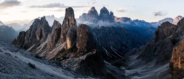 Tiro panorâmico de montanhas com um céu nublado no fundo — Fotografia de Stock