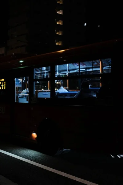 Colpo selettivo verticale di persone sedute all'interno di un autobus durante la notte — Foto Stock