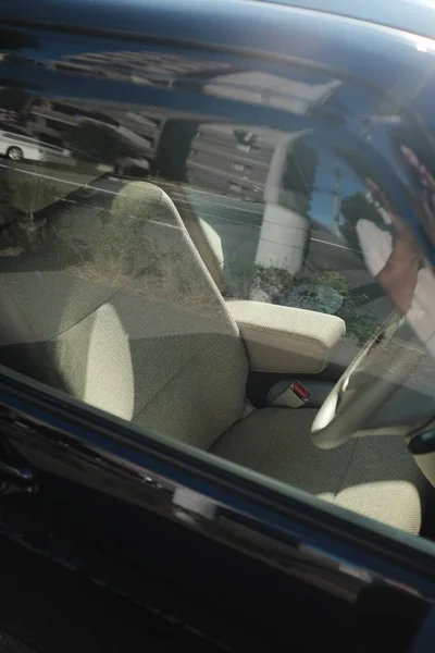 Вертикальный снимок сиденья бежевого водителя внутри черного автомобиля — стоковое фото
