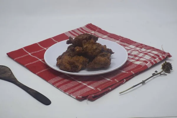 Κοντινό πλάνο από ψητά φτερά κοτόπουλου σε λευκό πιάτο με κόκκινο μαντήλι και λευκό φόντο — Φωτογραφία Αρχείου