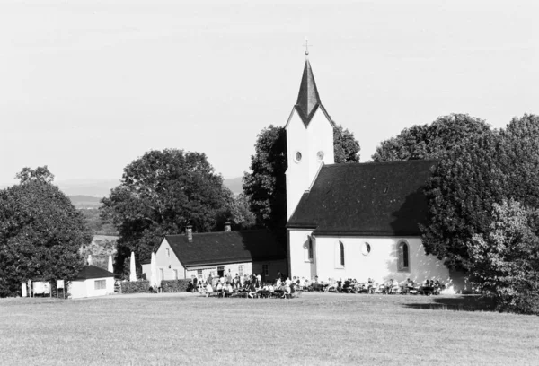 Beautiful shot of a church near trees with a clear sky in the background in black and white — Stock Photo, Image
